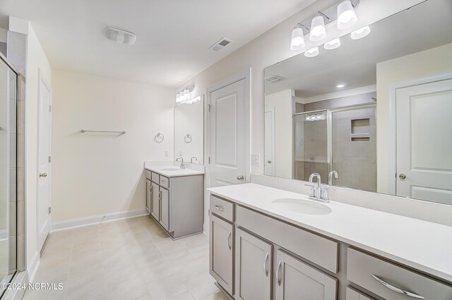 bathroom with tile patterned flooring, vanity, and an enclosed shower