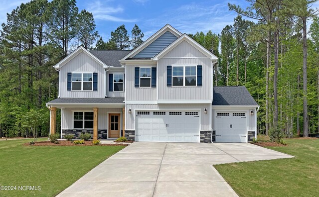 craftsman inspired home featuring a garage, a front lawn, and covered porch