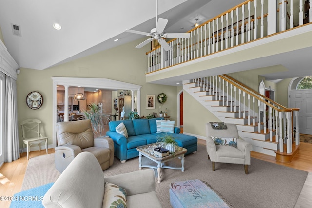 living room featuring ceiling fan, light hardwood / wood-style floors, high vaulted ceiling, and a wealth of natural light