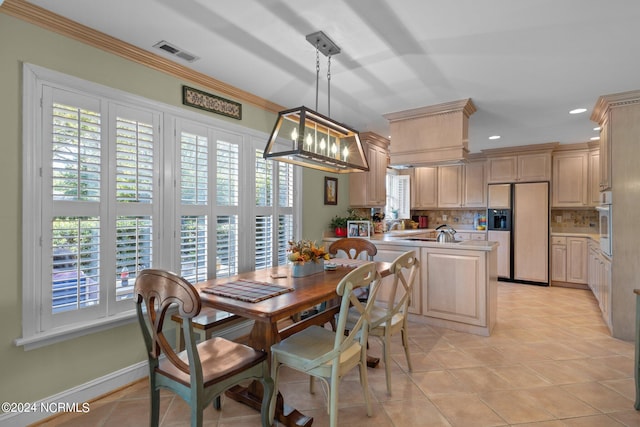 tiled dining area featuring a chandelier and ornamental molding