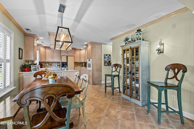 dining room featuring a wealth of natural light, crown molding, and light tile patterned flooring