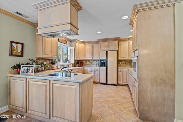 kitchen with black electric cooktop, paneled fridge, and light brown cabinetry