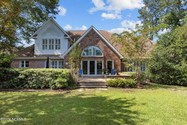 back of property with a yard and french doors