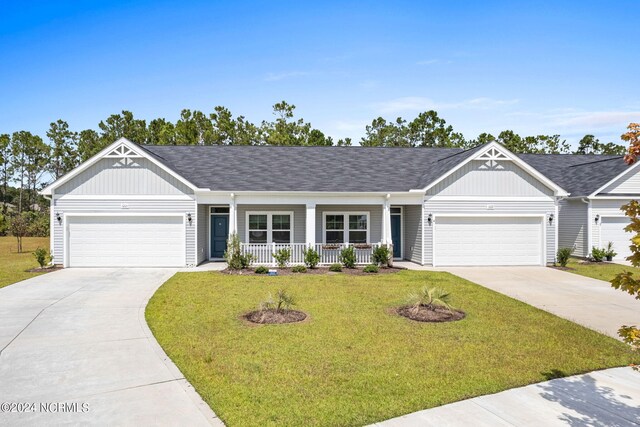 view of front of property with a yard, a porch, and a garage