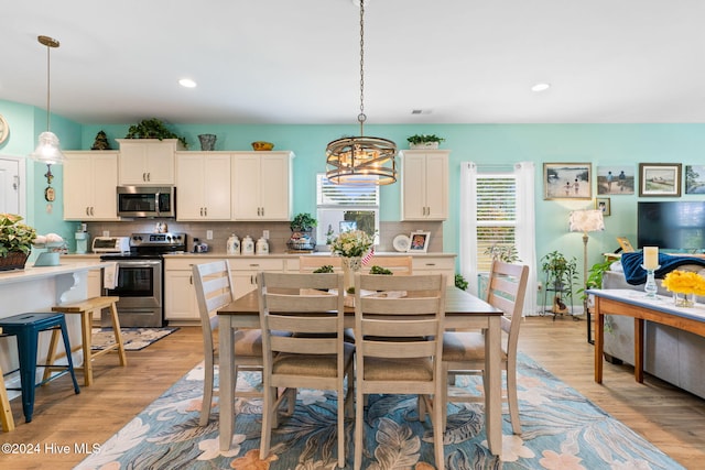 dining area featuring recessed lighting and light wood-style flooring