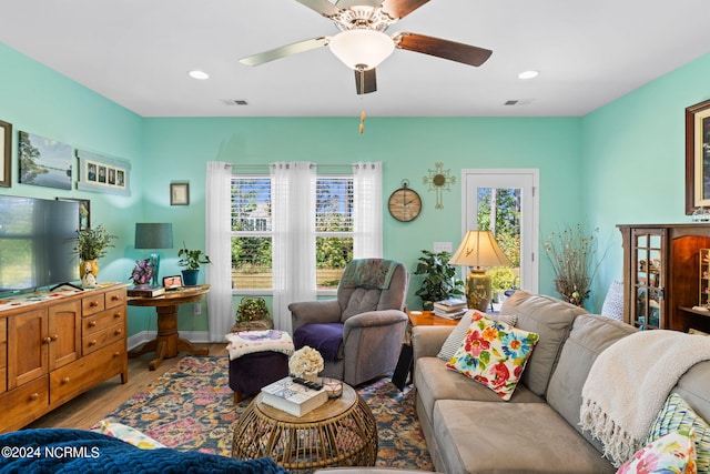 living room with a healthy amount of sunlight, visible vents, and wood finished floors