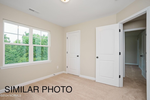 unfurnished bedroom featuring light carpet