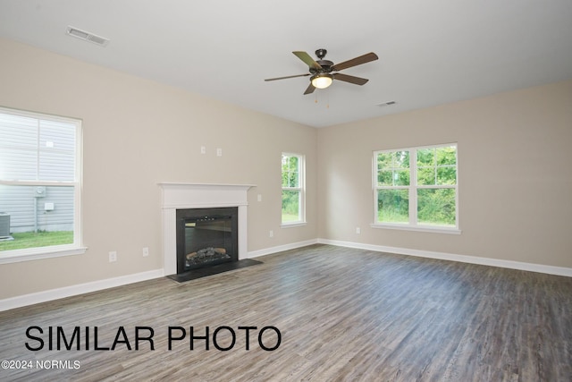 unfurnished living room with wood-type flooring, ceiling fan, and plenty of natural light