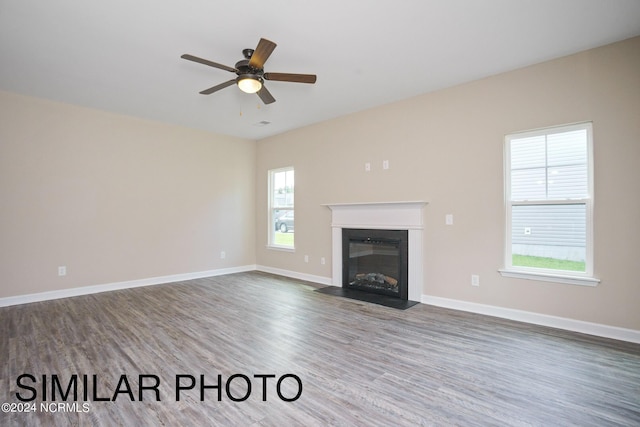 unfurnished living room with ceiling fan and hardwood / wood-style flooring