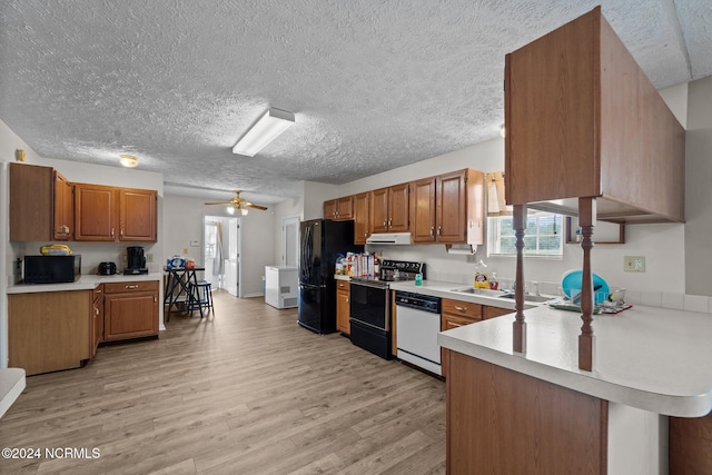 kitchen featuring black appliances, light wood-type flooring, ceiling fan, kitchen peninsula, and a textured ceiling