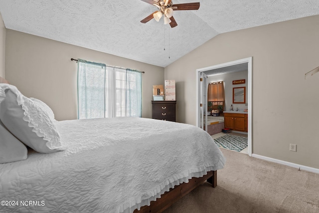 carpeted bedroom with vaulted ceiling, ensuite bathroom, ceiling fan, and a textured ceiling