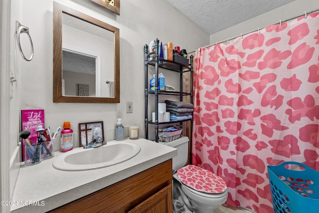 bathroom featuring vanity, toilet, curtained shower, and a textured ceiling