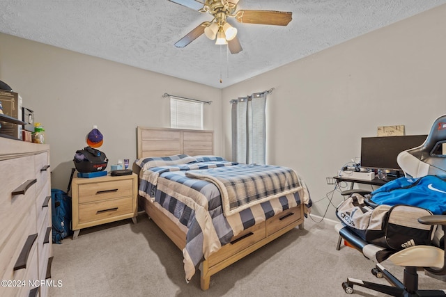 bedroom featuring ceiling fan, light carpet, and a textured ceiling