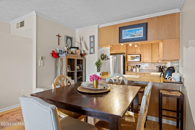 dining room featuring a textured ceiling and crown molding