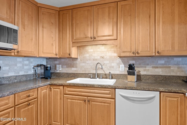 kitchen featuring decorative backsplash, sink, and white dishwasher