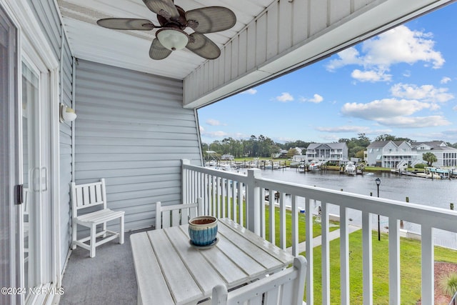 balcony with ceiling fan and a water view