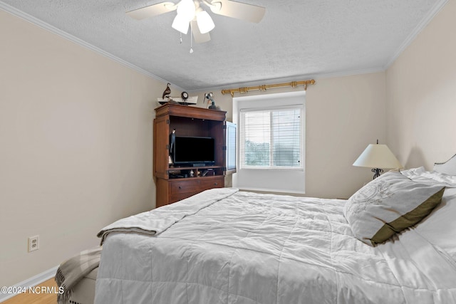 bedroom with a textured ceiling, crown molding, ceiling fan, and hardwood / wood-style flooring