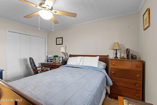 bedroom featuring ceiling fan, a textured ceiling, a closet, and ornamental molding