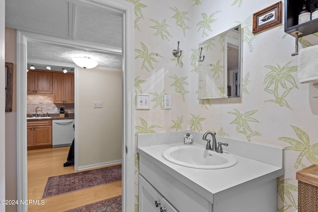 bathroom with wood-type flooring, vanity, a textured ceiling, and tasteful backsplash