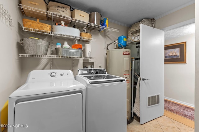 laundry area with light tile patterned floors, ornamental molding, washing machine and clothes dryer, a textured ceiling, and water heater