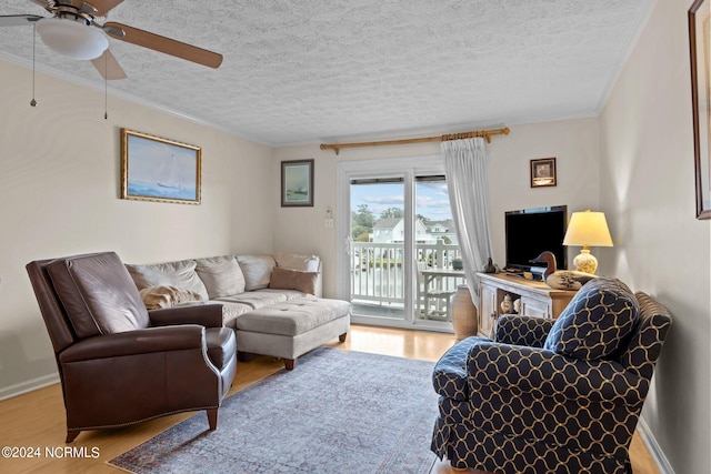 living room with light wood-type flooring, ceiling fan, and crown molding