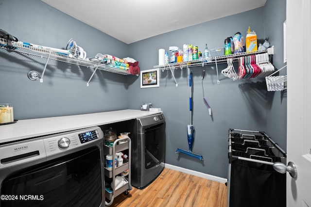 laundry room featuring wood-type flooring and washer and clothes dryer