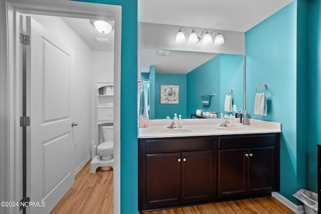 bathroom featuring vanity, toilet, and hardwood / wood-style floors