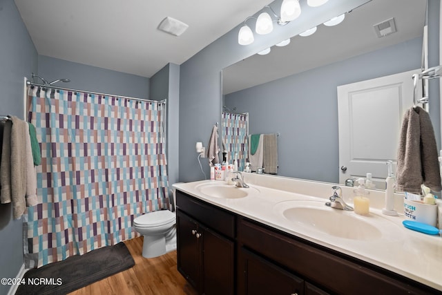 bathroom with walk in shower, wood-type flooring, toilet, and vanity