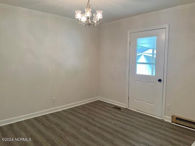 doorway to outside featuring a chandelier, crown molding, and dark hardwood / wood-style flooring