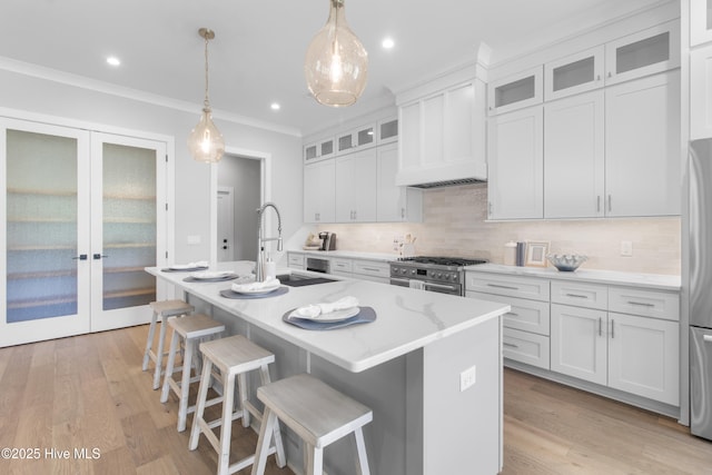 616 Waterstone Dr, Wilmington, NC 28411 - kitchen with stainless steel appliances, a sink, decorative backsplash, an island with sink, and white cabinetry