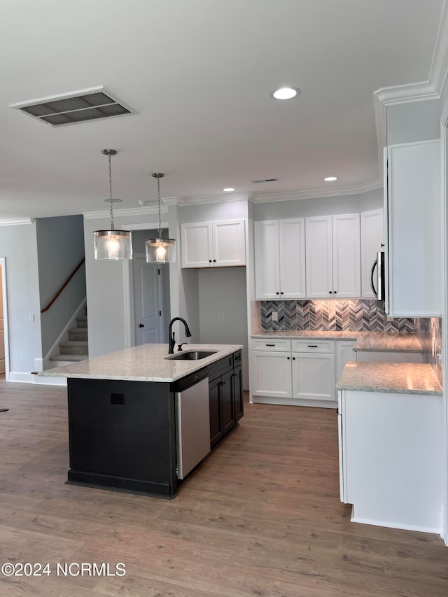 kitchen featuring white cabinetry, sink, stainless steel appliances, and an island with sink