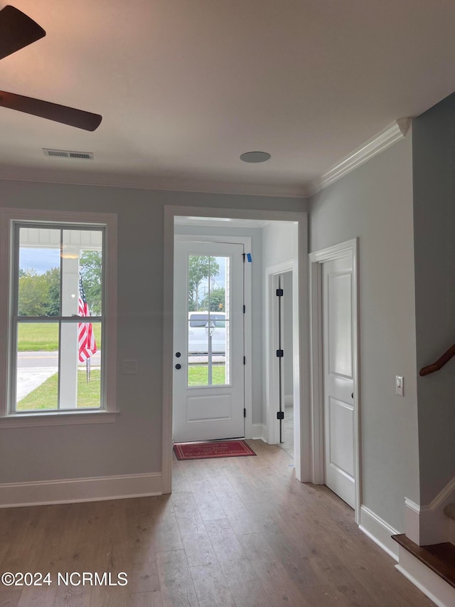 entryway featuring ceiling fan, light wood-type flooring, and crown molding