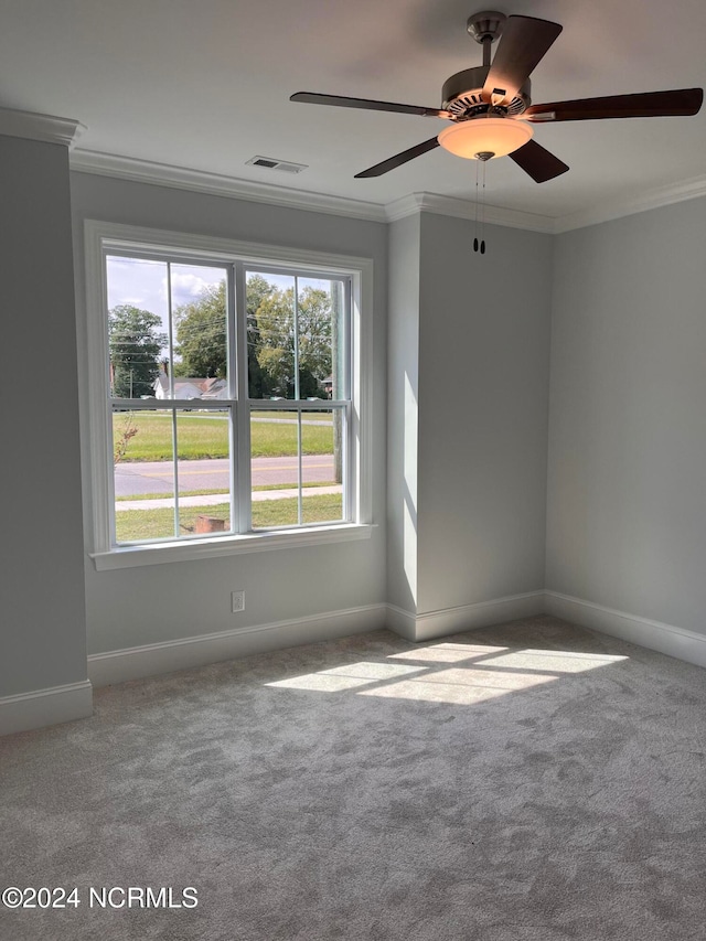 carpeted spare room with ceiling fan and crown molding