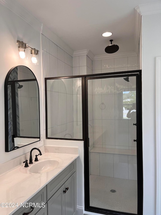 bathroom featuring a shower with shower door, vanity, and crown molding