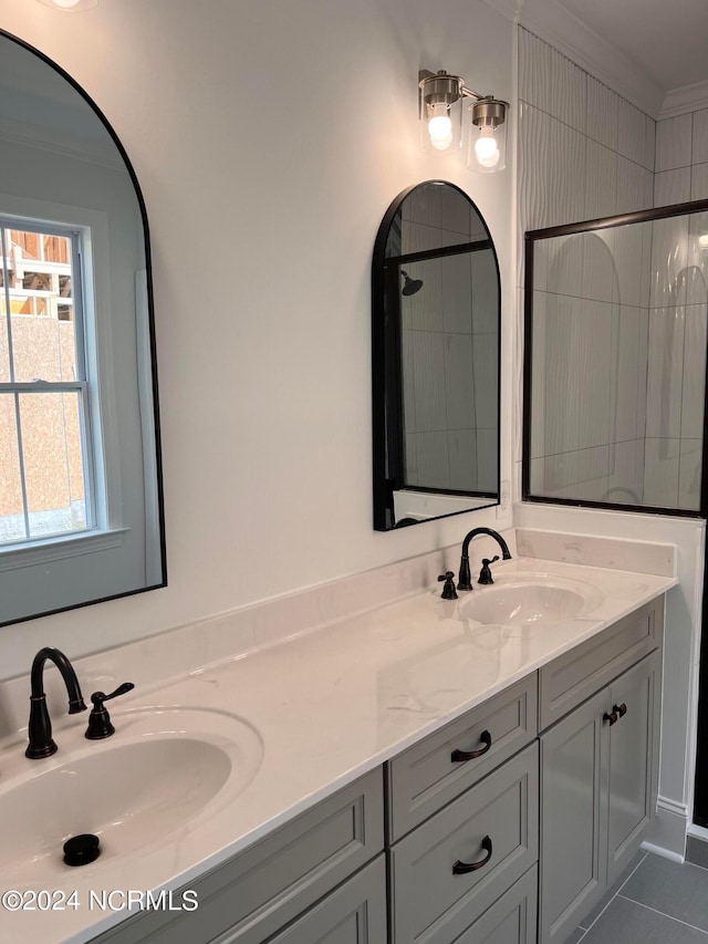 bathroom with a tile shower, tile patterned flooring, vanity, and ornamental molding