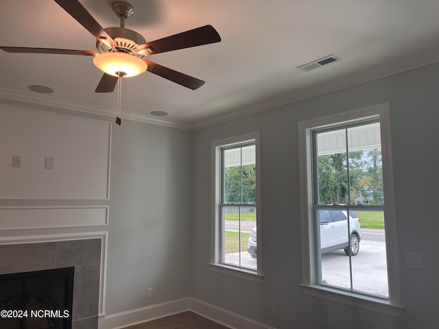 unfurnished living room with ornamental molding, ceiling fan, a tile fireplace, and dark hardwood / wood-style floors