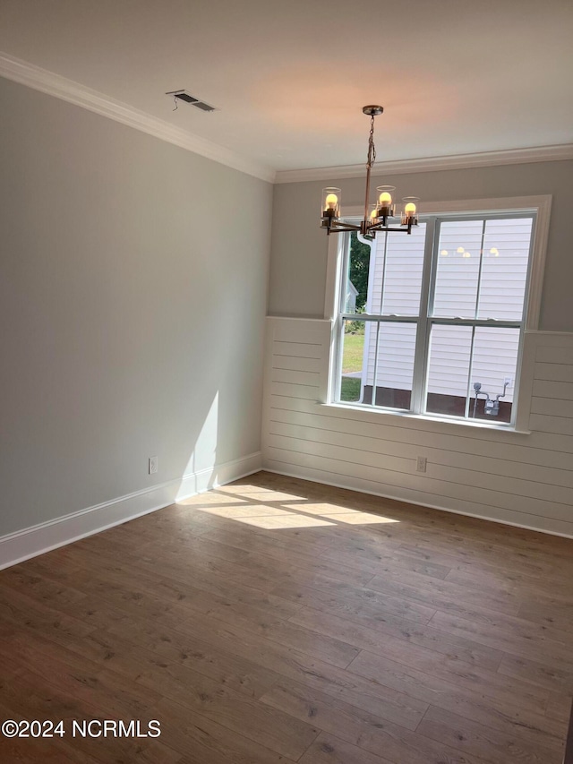 unfurnished room with a notable chandelier, crown molding, and hardwood / wood-style flooring