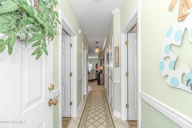 hallway featuring crown molding and light tile patterned floors