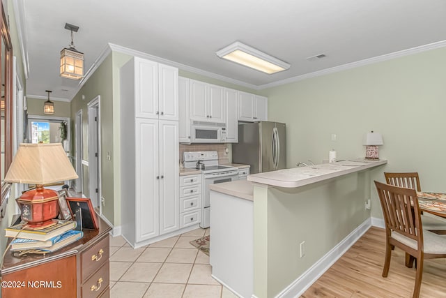 kitchen with white cabinets, white appliances, kitchen peninsula, crown molding, and decorative light fixtures