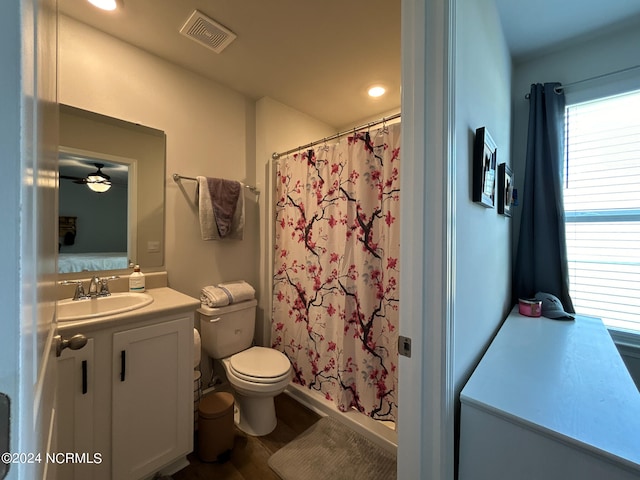 bathroom featuring ceiling fan, vanity, toilet, walk in shower, and hardwood / wood-style floors