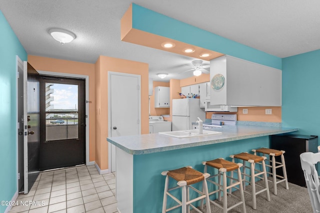 kitchen with ceiling fan, white cabinets, kitchen peninsula, and white appliances