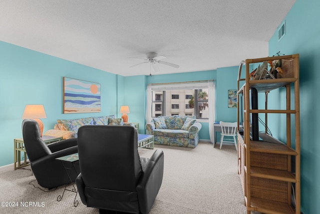 carpeted living room featuring ceiling fan and a textured ceiling