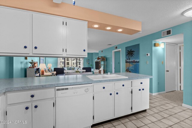 kitchen with white cabinets, white dishwasher, light tile patterned flooring, sink, and kitchen peninsula