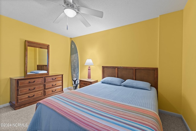 bedroom featuring ceiling fan, a textured ceiling, and carpet