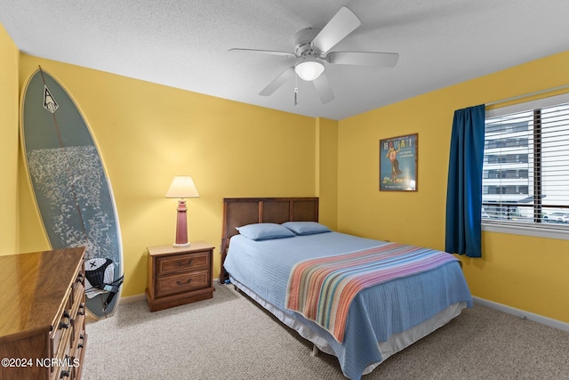 bedroom featuring a textured ceiling, ceiling fan, and light colored carpet