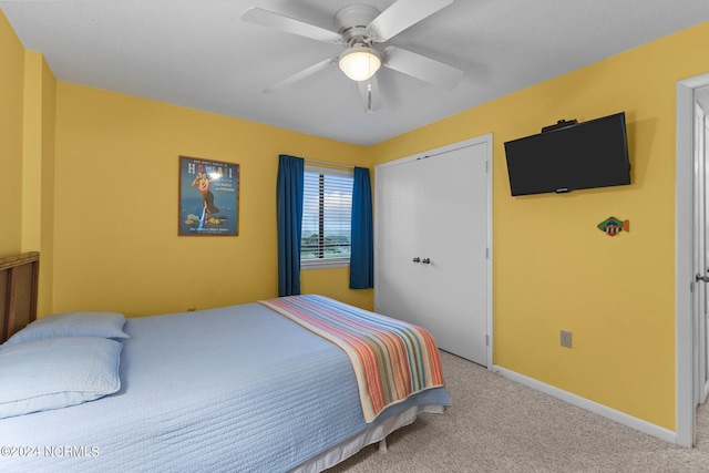 carpeted bedroom with ceiling fan and a closet