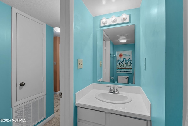 bathroom with tile patterned flooring, vanity, and toilet