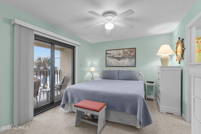 carpeted bedroom with a textured ceiling, ceiling fan, and access to exterior