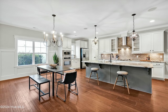 kitchen featuring white cabinetry, wall chimney range hood, dark hardwood / wood-style flooring, a kitchen island with sink, and appliances with stainless steel finishes