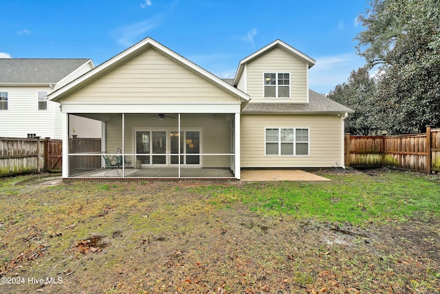 back of property with a sunroom, ceiling fan, a patio area, and a lawn